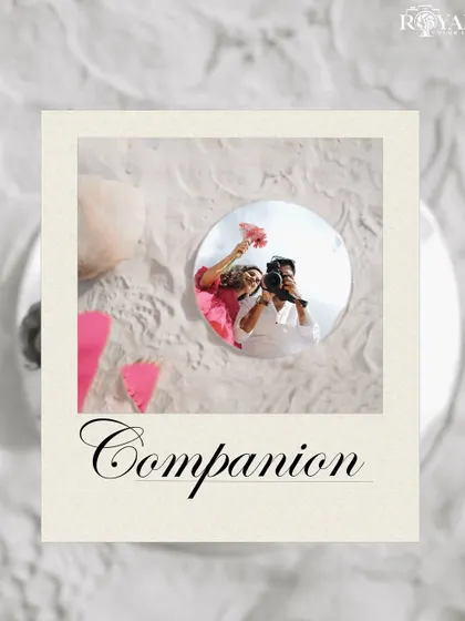 A creative flat-lay style shot showing a reflection of the couple in a mirror, surrounded by sand and flowers.
