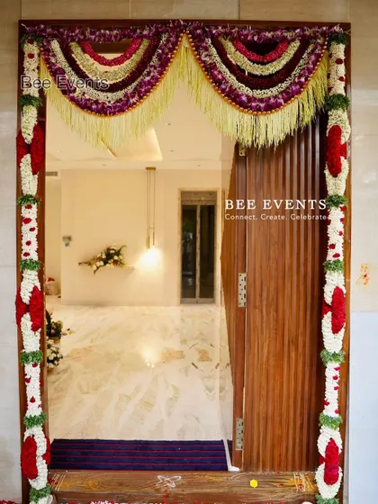 A beautifully framed shot of a main door decorated with traditional floral garlands. The symmetry and rich colors make for a perfect welcome.