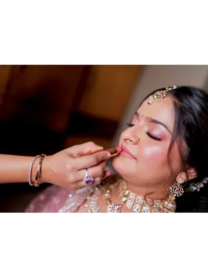 A close-up action shot of me applying lipstick, a crucial final step for the perfect bridal pout.