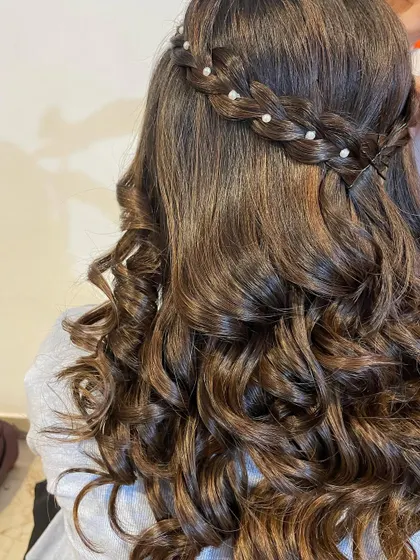 A lovely half-up, half-down hairstyle with a waterfall braid. The soft curls are accented with small pearls for a delicate and romantic look.