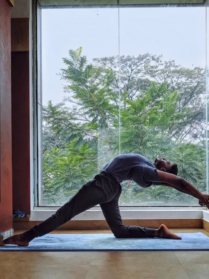 A deep lunge with a backbend, Anjaneyasana, practiced against a window framing the evening sky. It feels like reaching for that last ray of sunshine.
