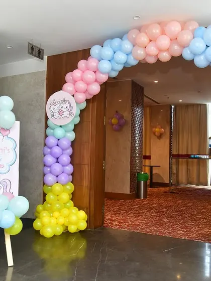 This unicorn-themed entrance features a pastel rainbow balloon arch and a matching welcome sign, creating a cheerful and inviting entryway for a magical birthday party.