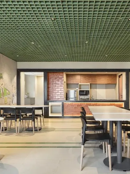 A bright and airy cafeteria space with cartoon-style wall murals. This playful design adds character and a sense of fun to the office, making the cafeteria a lively spot for employees to recharge.