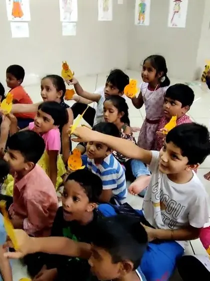 A wide shot of the children's puppetry class, showing everyone busy with their creations. The room is always buzzing with energy and excitement during these sessions.