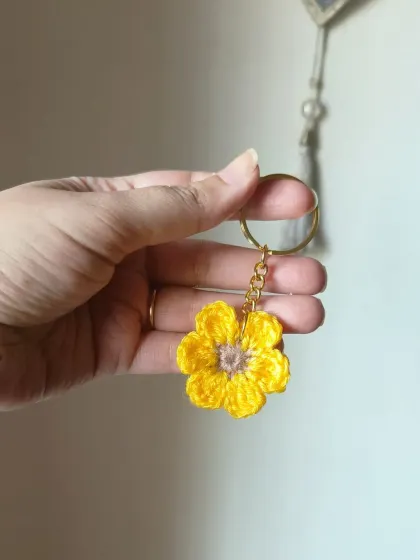 A cheerful yellow floral keychain, perfect for brightening up your keys.