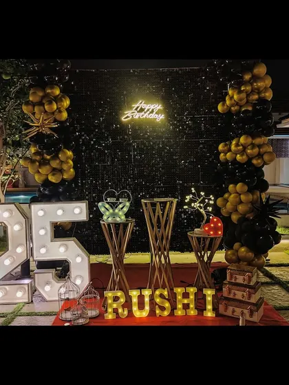 An elegant outdoor 25th birthday celebration by the pool. We used a black sequin wall, gold and black balloons, and marquee lights to create a sophisticated and memorable party atmosphere at night.
