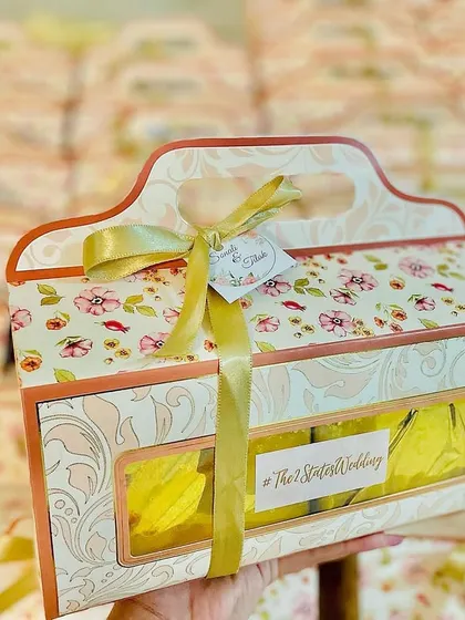 A close-up of the floral wedding favor box, showing the custom hashtag and beautiful presentation.