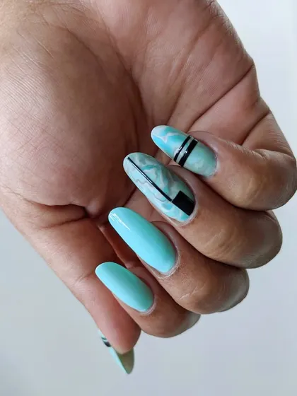 A cool, modern design featuring a turquoise base with a marbled accent nail and bold black geometric lines.