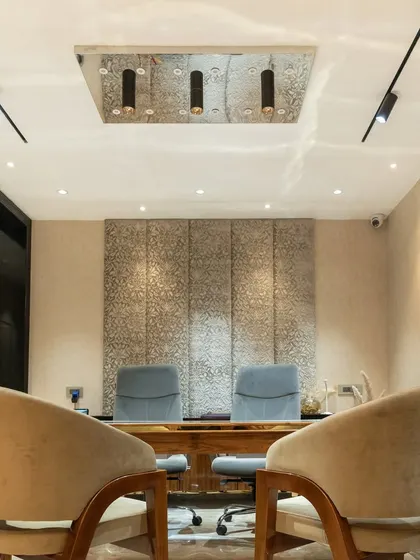This is the private consultation area within the boutique. I used comfortable, upholstered chairs and a textured fabric wall panel as a backdrop to create a sense of intimacy and focus for client discussions.