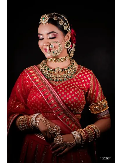 The beauty of a traditional red bridal lehenga is undeniable. The makeup here features a classic red lip, defined eyes, and glowing skin to match the richness of the outfit.