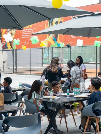 Guests enjoying the outdoor seating and food at the football-themed celebration.