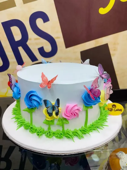 A lovely 2kg butterfly garden cake with piped flowers and colorful butterfly toppers.