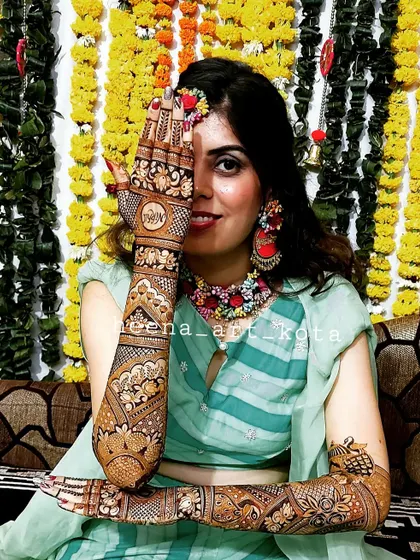A stunning bride posing with her intricate back-hand mehndi design.