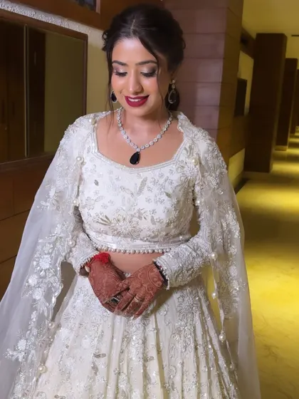 Vaishali's Sangeet look was all about making a statement. The bold red lip provides a stunning contrast to her white outfit, while the smokey eye adds a touch of glamour.