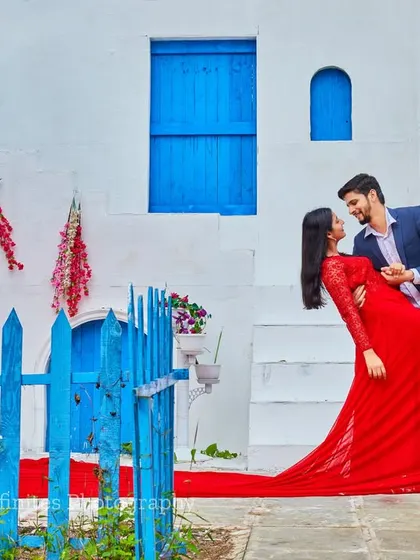 The vibrant contrast of a red gown against the blue and white of our Santorini set makes for a visually stunning and romantic pre-wedding photograph.