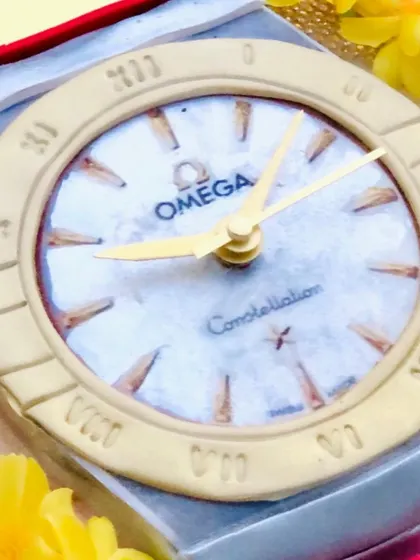 A close-up of the Omega watch cake face, showing the incredible detail of the logo, hands, and hour markers.