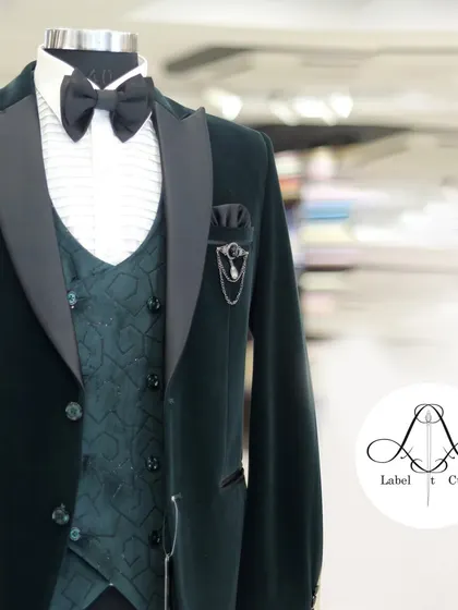 Another angle of the exquisite green velvet tuxedo. The blurred background emphasizes the sharpness of the tailoring and the richness of the color, showing how each thread tells a tale of craftsmanship.