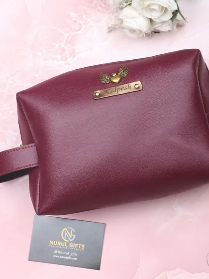 A beautiful maroon leather pouch, personalized with a name and a heart-with-wings charm.