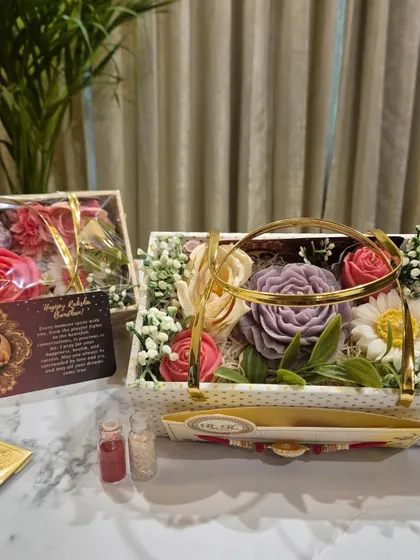 My Flower Bouquet Gift Hamper, specially designed for Raksha Bandhan. This one includes four floral candles, a rakhi, roli chawal, and a customizable message card.
