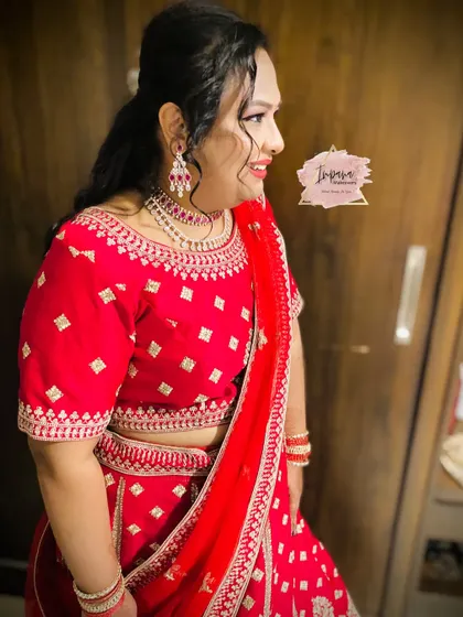 A gorgeous non-bridal reception look in a vibrant red lehenga. The makeup is kept glamorous with defined eyes and a matching lip color.