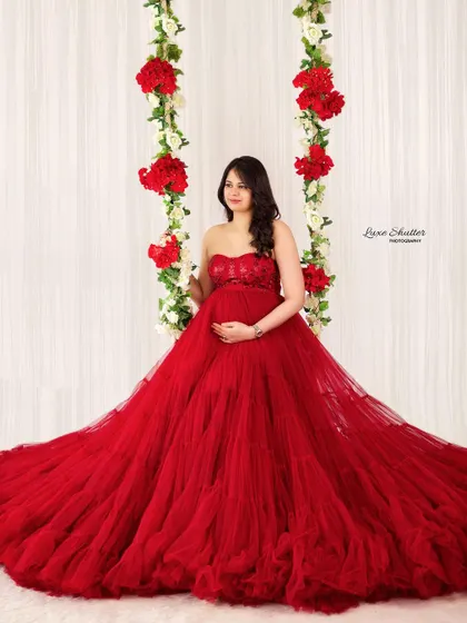 A fairytale moment on a floral swing. This beautiful red gown with its voluminous tulle skirt creates a truly magical and romantic scene.