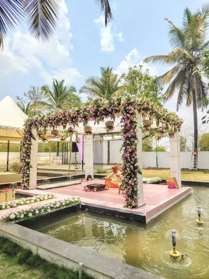 A stunning floral mandap set over water for a unique wedding ceremony.