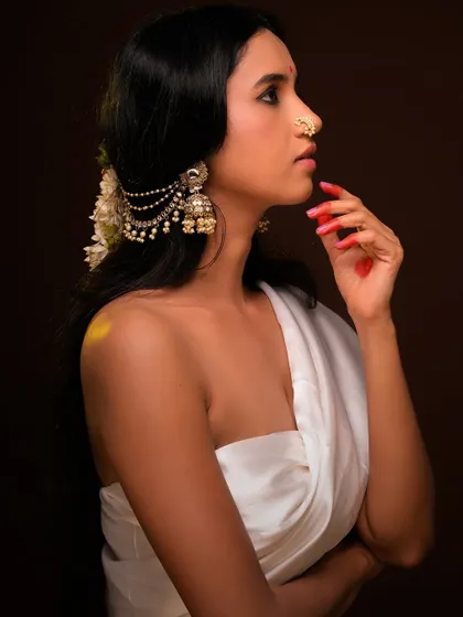 A profile view that highlights the traditional jewelry and the elegant hairstyle adorned with flowers.