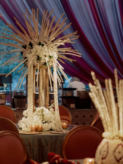 A unique, starburst-style centerpiece made from hundreds of tuberose strings. This sculptural floral piece adds a modern twist to a traditional wedding flower.