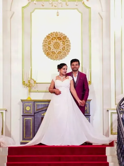 A regal pre-wedding portrait on a grand staircase. The bride to be wears our classic white A-line wedding gown.