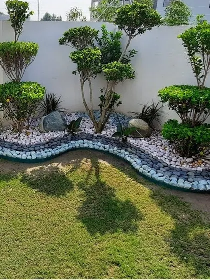 Our landscape design services go beyond just plants. Here, we created a unique pebble riverbed feature with sculpted shrubs and rock placements to build a serene, zen-inspired front yard.