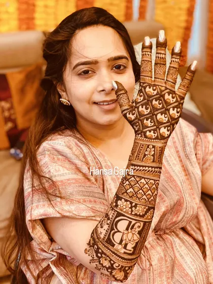 This back-of-hand design features a beautiful monogram with a floral touch, surrounded by intricate elephant patterns. It's a perfect blend of personalization and tradition.