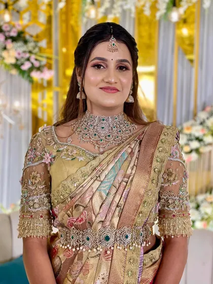 This bride looks stunning in her pastel green and gold saree for her reception. The custom-designed blouse with intricate 3D floral embroidery is a true work of art.