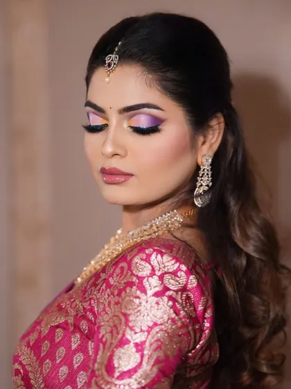 A soft glam look with a dramatic twist. The purple and pink eyeshadow adds a pop of color that makes the eyes stand out, paired with a soft pink lip.