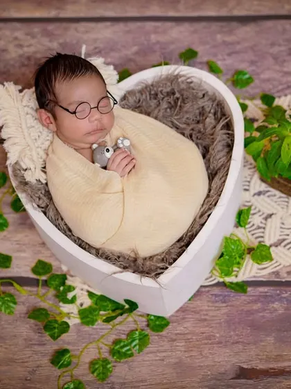 A heart of green. This nature-inspired setup places the baby in a heart-shaped bowl, surrounded by ivy and rustic textures.
