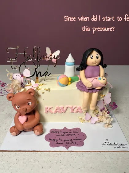 Celebrating a special milestone with a "Halfway to One" cake. This design features a fondant mom and baby, a teddy bear, and other baby-themed toppers for a six-month celebration.