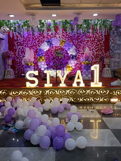 The full stage view with large marquee letters spelling 'SIYA 1' in front of a purple and pink flower wall.