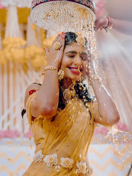 Capturing the pure joy of the Haldi ceremony. The bride is showered with flowers and turmeric, and my decor with its bright yellow drapes and floral accents creates a perfectly festive atmosphere.