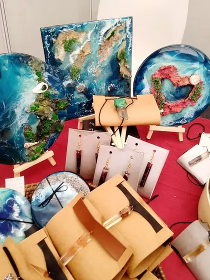 My stall at a pop-up event, showcasing my handmade resin art, including ocean-themed wall pieces, coasters, and jewelry. Many of these items are repurposed from waste.