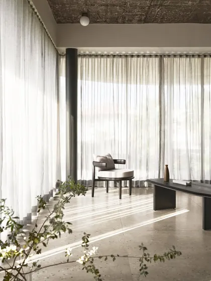 Sunlight filters through the sheer curtains in the living room of Pavilion House, creating a serene and peaceful atmosphere.