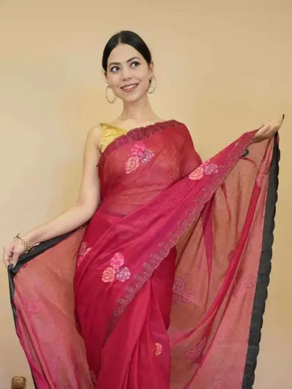 A lovely red Kota Doria saree with floral embroidery. This lightweight and comfortable saree is pre-stitched, making it an excellent choice for summer events and daytime functions.