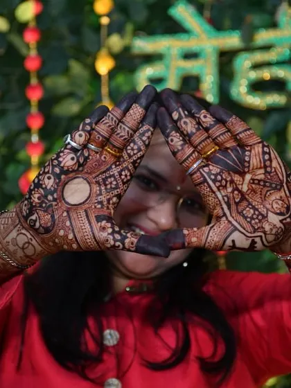 A playful pose from a happy client, showing off the fantastic stain color against the festive backdrop of her mehendi ceremony.