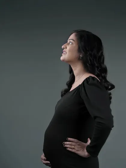 A solo portrait of the mother-to-be looking upwards with a hopeful expression. This shot, taken during a studio session, focuses on her anticipation and joy.