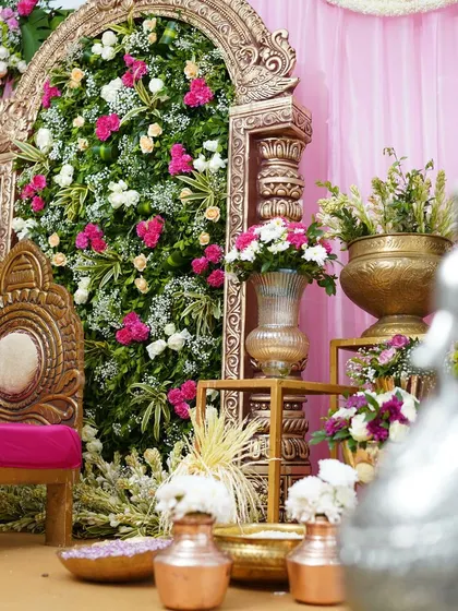 A different angle of the intimate celebration setup, showing the arrangement of props and floral vases. The silver peacock is out of focus in the foreground, drawing the eye to the main stage.