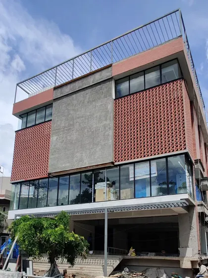 This commercial building, seen here under construction, features a terracotta screen facade to shield the glass from the harsh sun.