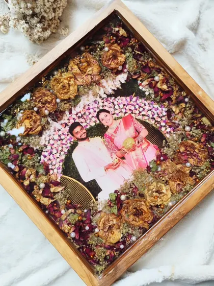 This 14x14 inch teakwood frame is one of my favorites. The simple arrangement of preserved varmala flowers with pearls creates a beautiful and elegant piece.