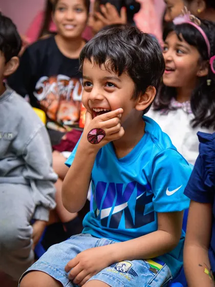 A look of pure delight on this boy's face as he watches the entertainment, a temporary tattoo visible on his hand.