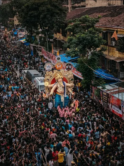 A top-down drone view of the Ganesh Chaturthi procession, showing the massive idol moving through a sea of devotees. This angle captures the event's true scale.