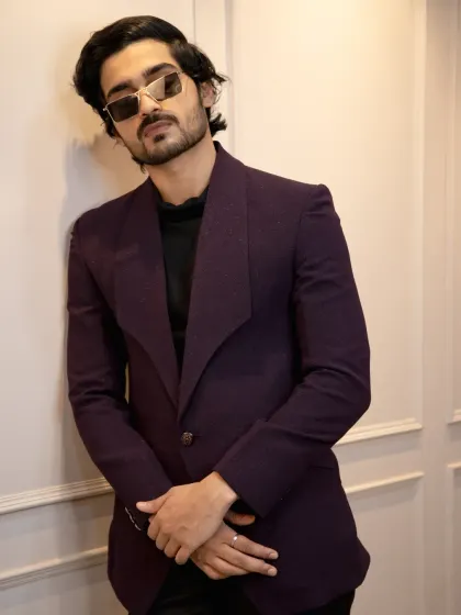 A full look at the wine-colored tuxedo. The unique wide lapel and single-button closure create a modern, fashion-forward silhouette that's perfect for a cocktail party or sangeet.