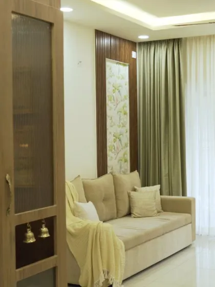 This angle shows the relationship between the living area and the compact puja unit, highlighting how different functional zones can coexist in an open-plan layout.