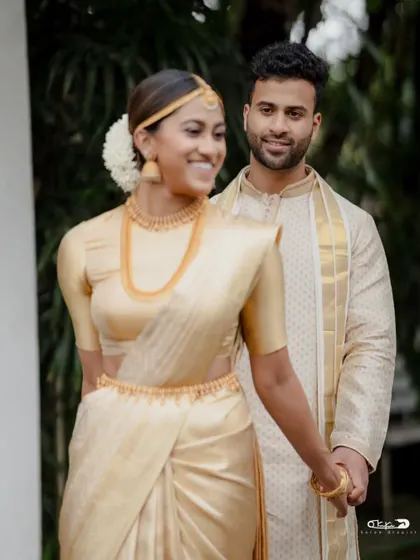 A perfect match. I draped the groom in a classic kasavu mundu and angavastram that beautifully complemented the bride's golden saree, creating a coordinated and elegant look for their special day.